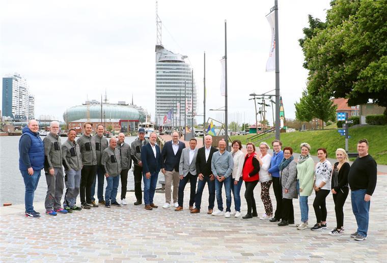 Gruppenfoto von rund 20 Personen auf einer Uferpromenade in Bremerhaven mit Skyline und Hafen im Hintergrund.