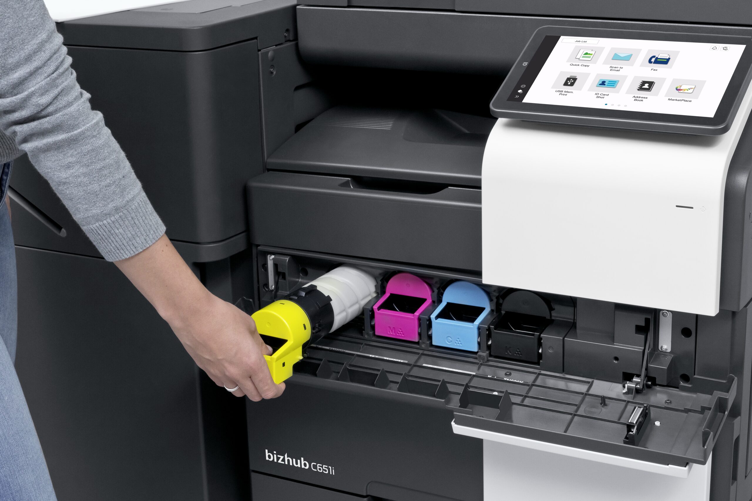 Person tauscht die gelbe Tonerkartusche an einem modernen Multifunktionsdrucker mit Touchscreen-Bedienfeld aus.