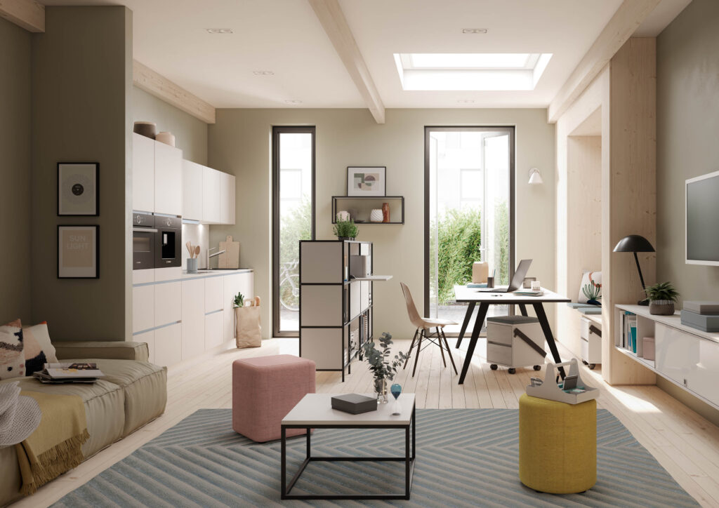 Helles Wohn- und Arbeitszimmer mit offener Küche, Schreibtisch am Fenster und modernem, freundlichem Interieur in Naturtönen.