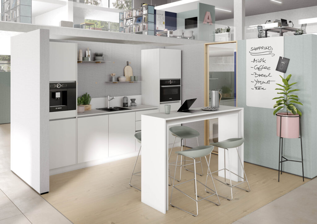 Moderne Büroküche mit weißer Einrichtung, hohem Tisch mit Hockern und Notiztafel für Einkaufsliste an der Wand.